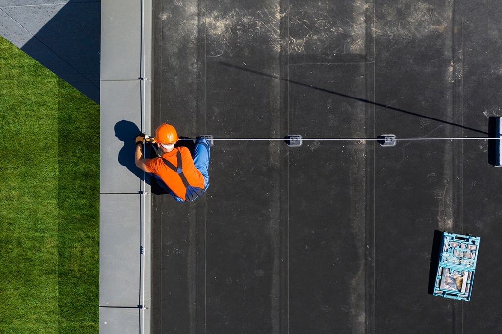Technicien installant un paratonnerre au sommet d'un bâtiment